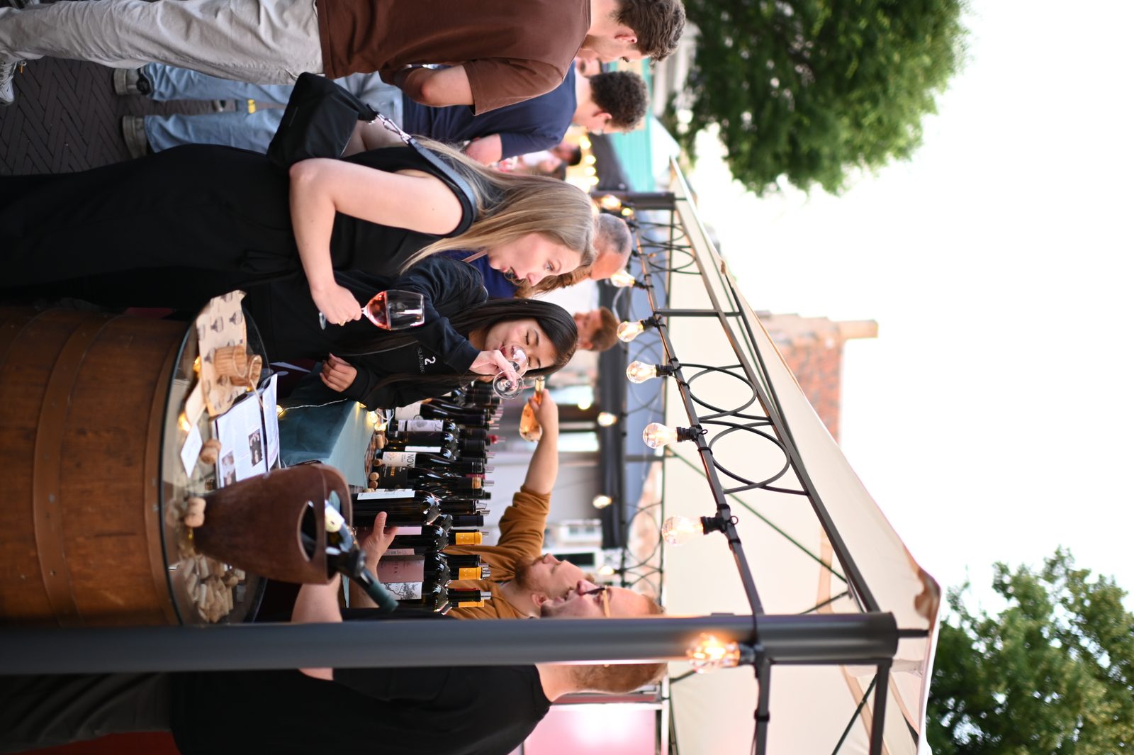 Guest tasting wine at a festival booth in Utrecht.