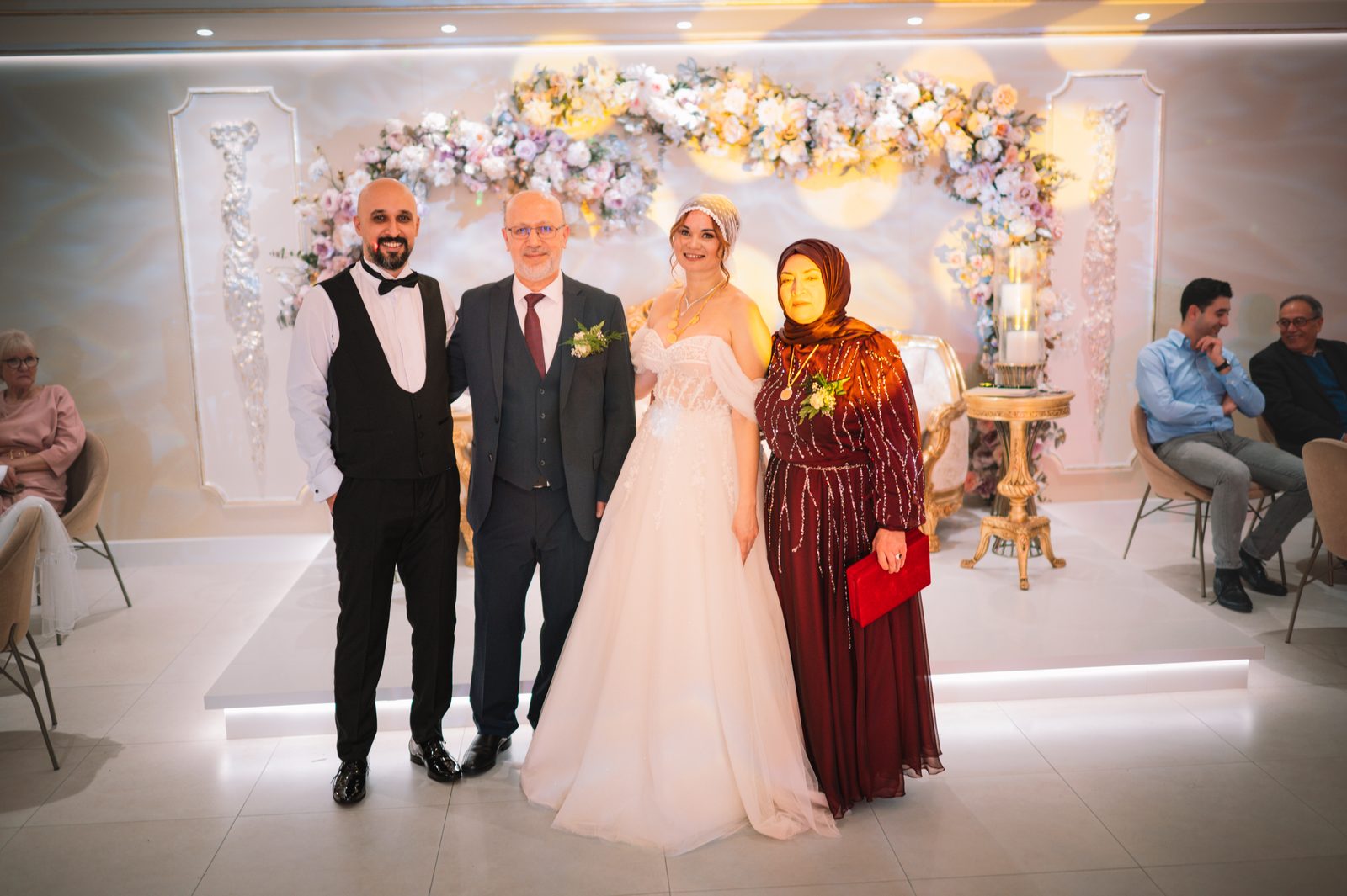 Wedding couple photographed with family during a wedding celebration.