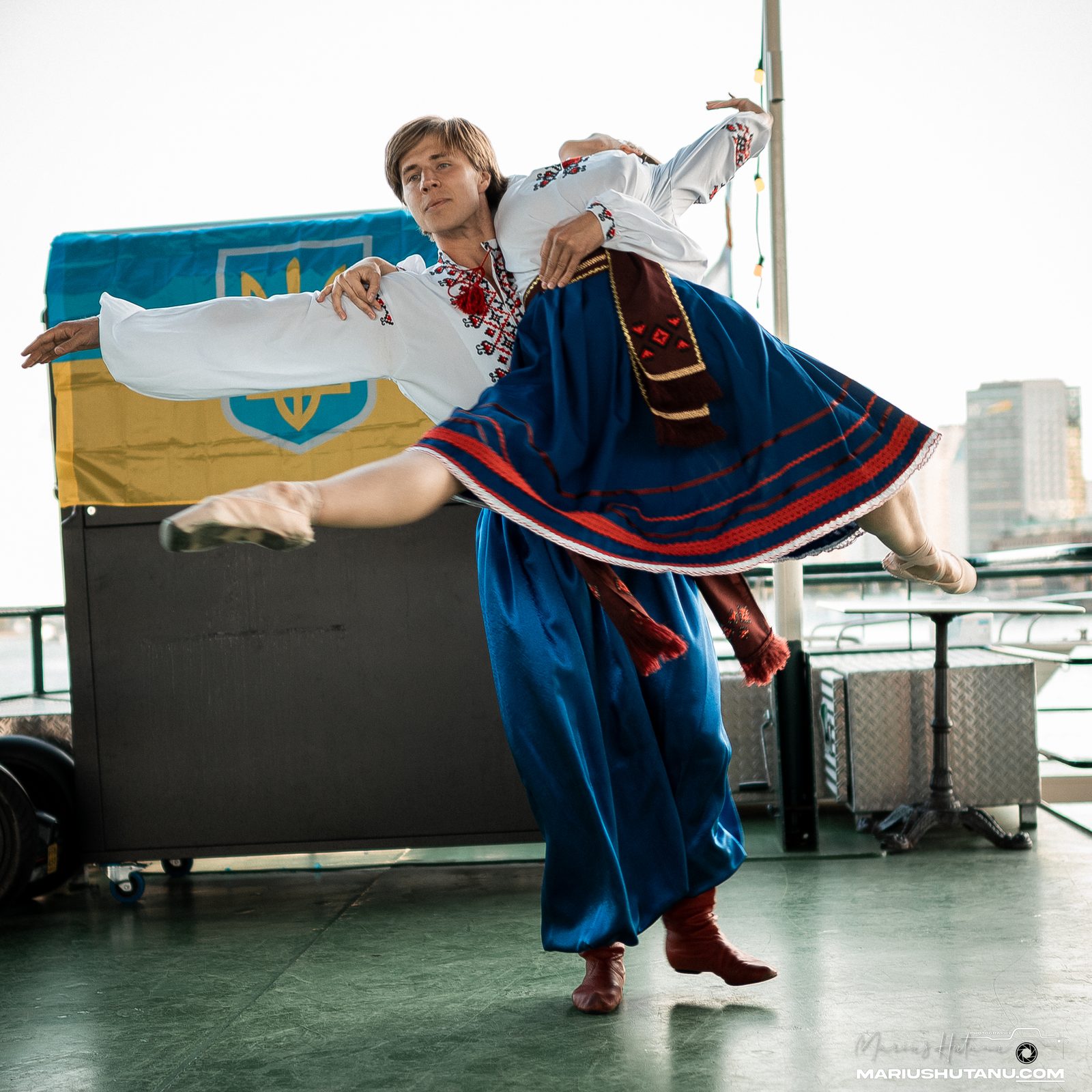Dancer in traditional colors performing on a boat deck.